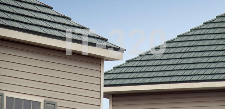 Tan house with garage with green asphalt shingles.