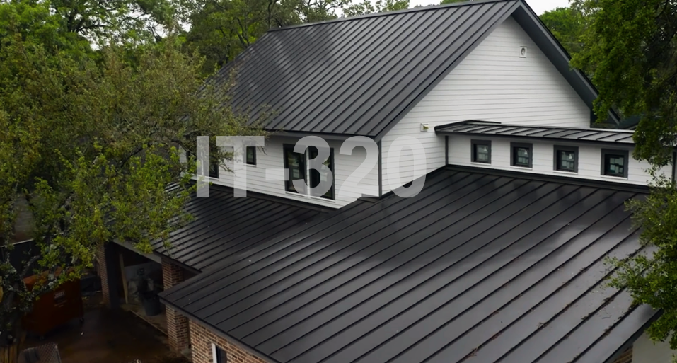 White house with garage with black metal roof.